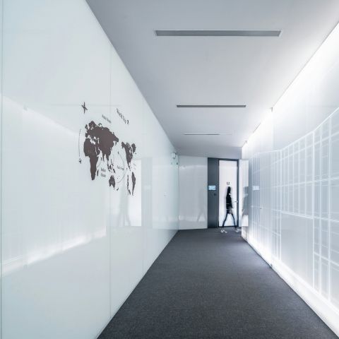 Person walking in a hallway with a map on the wall